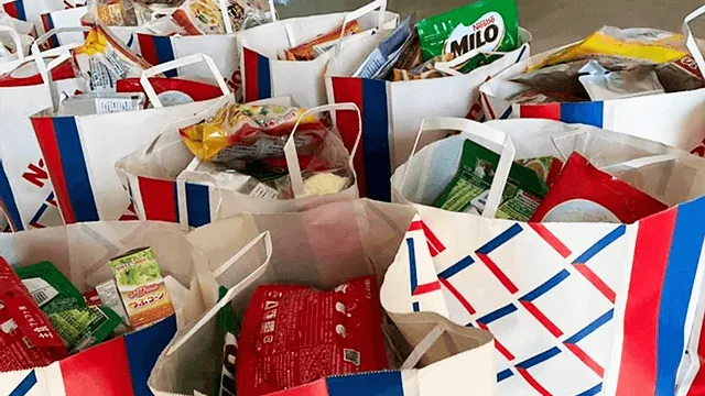 写真：写真に収まりきらない数の紙袋にそれぞれ食べ物が分けられている